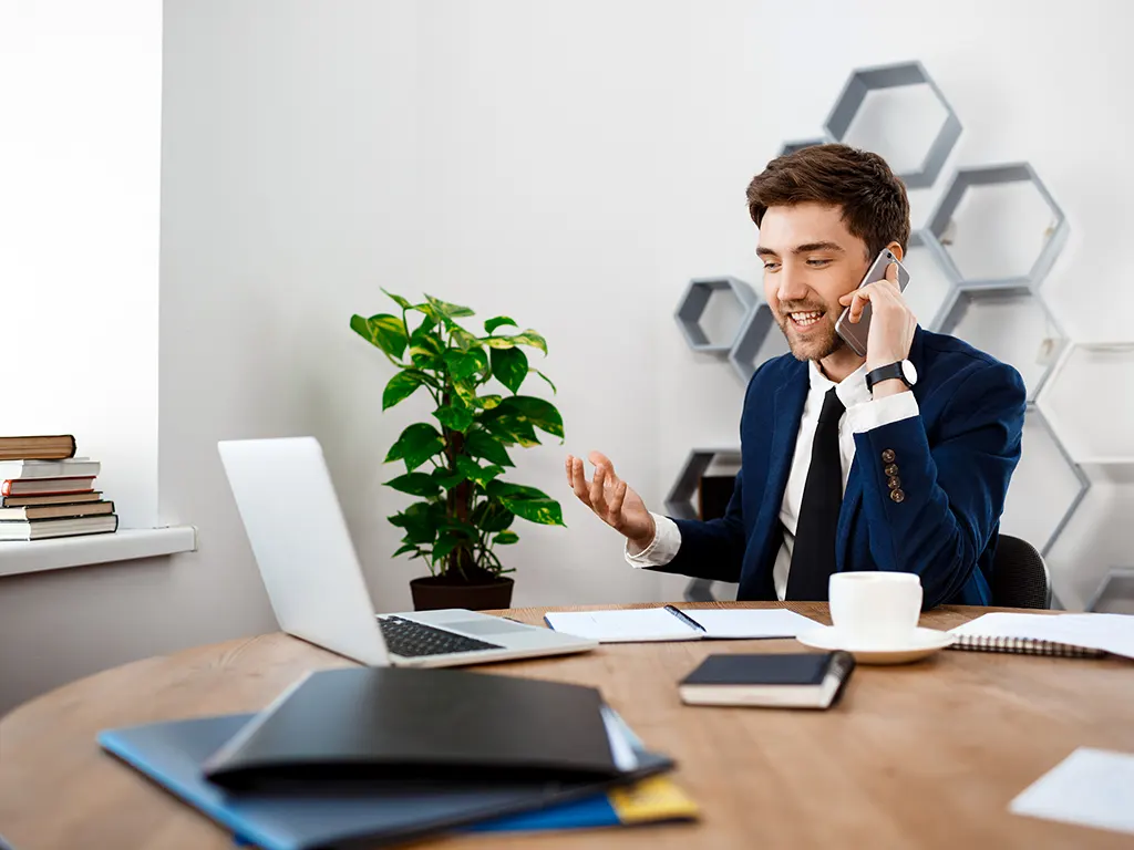 young-successful-businessman-speaking-phone-office-background